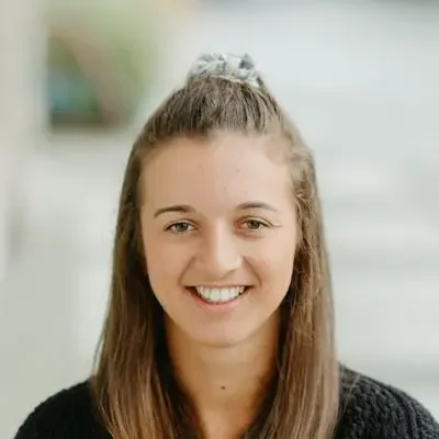 Katharine smiling at the camera while wearing a black sweater.